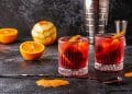 Negroni cocktail with orange peel and ice.