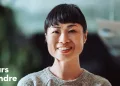 Portrait d’une femme souriante avec un fond flou et le texte "Toujours apprendre" en blanc.